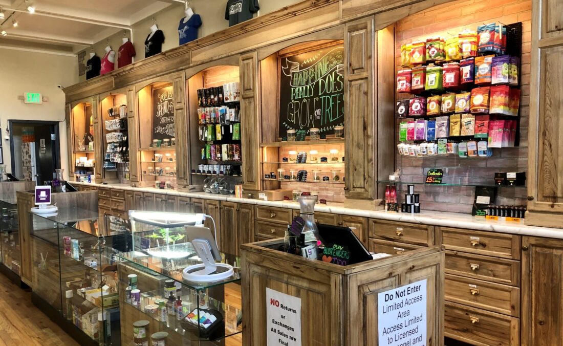 Freedom Road dispensary interior displaying well-lit walls and glass cases with cannabis products for sale.